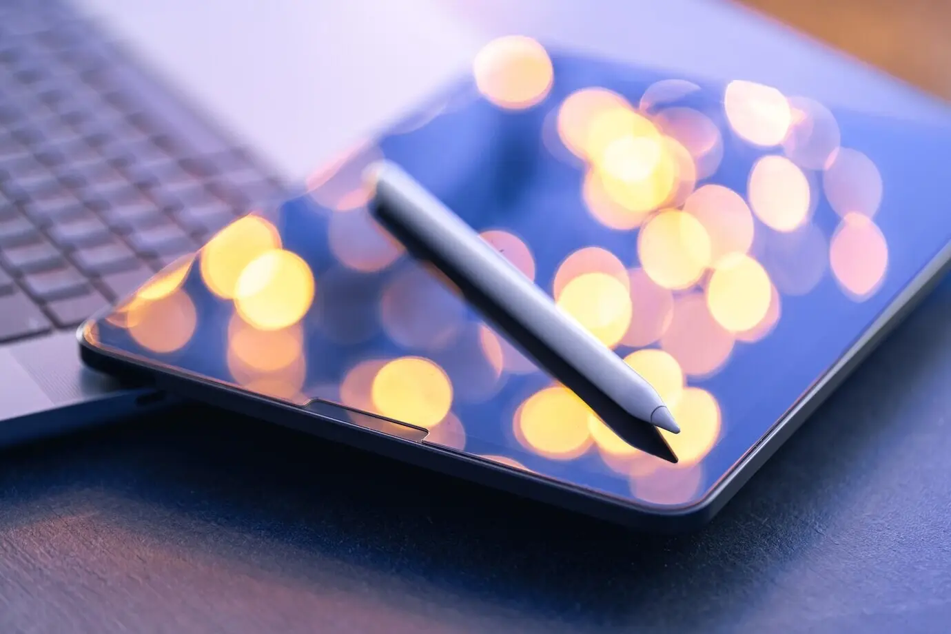 Стилус для цифрового планшета и ноутбук на рабочем столе, крупный план.